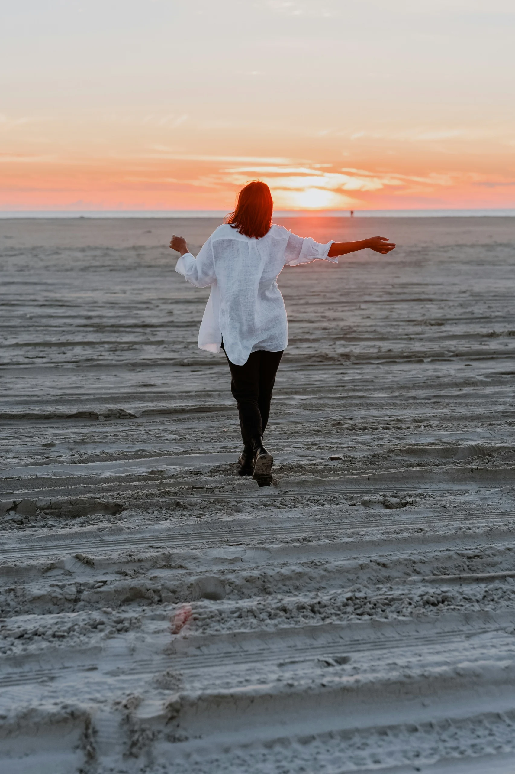 jasmin-ne-zGt8kUIROyI-unsplash Woman enjoying walking on the beach at sunset